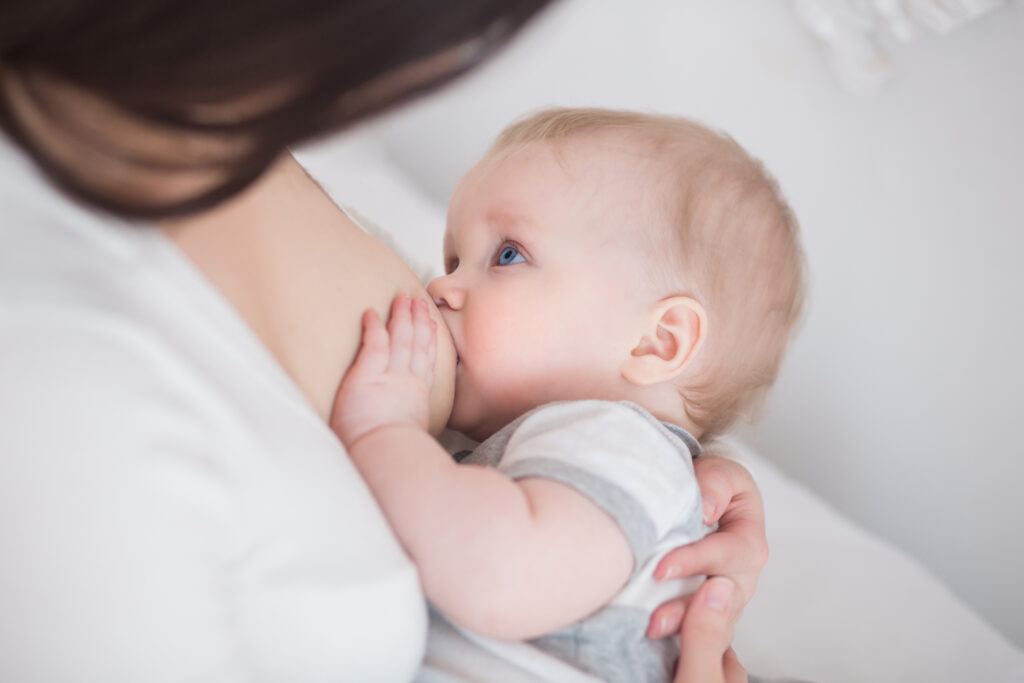 Mutter, die gerade ihr Baby an der Brust füttert.